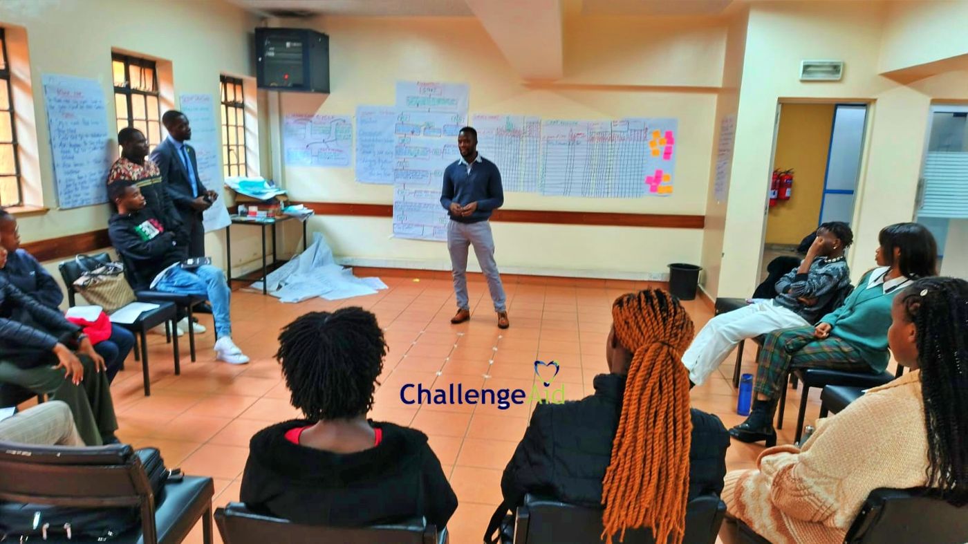 ChallengeAid team workshop with facilitator presenting to a seated group